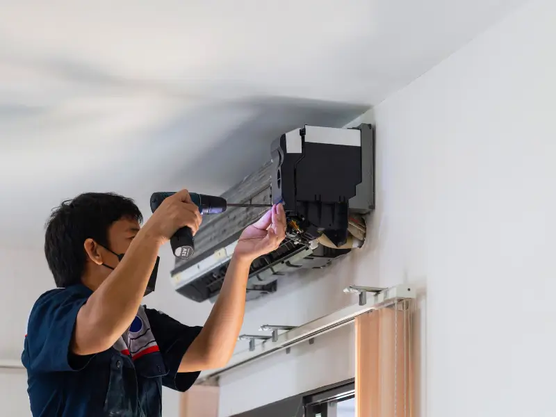 Professional AC maintenance engineer servicing air conditioning unit in Dubai